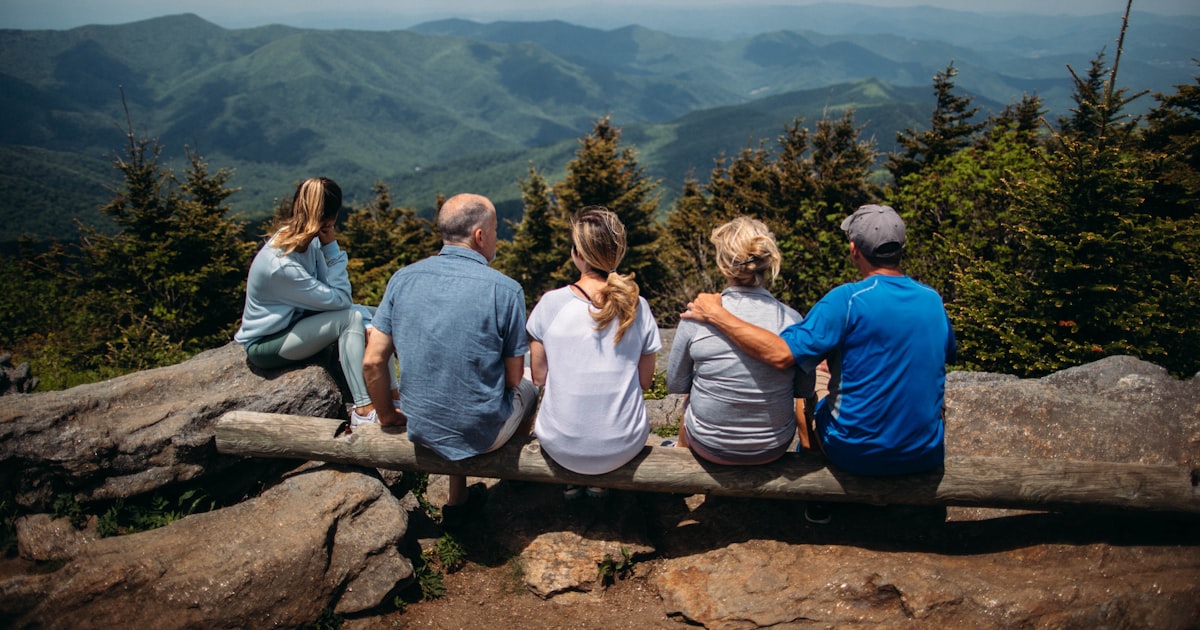 A family resting on rocks, looking out over the mountains